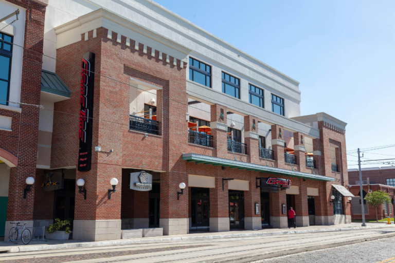 Brick commercial building with street-level storefronts and upper-floor windows