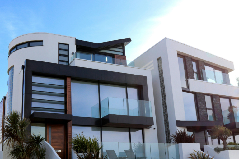 Contemporary home exterior with glass balconies and contrasting architectural finishes