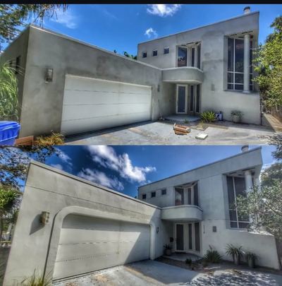 Stucco application and repair progress on a two-story home exterior